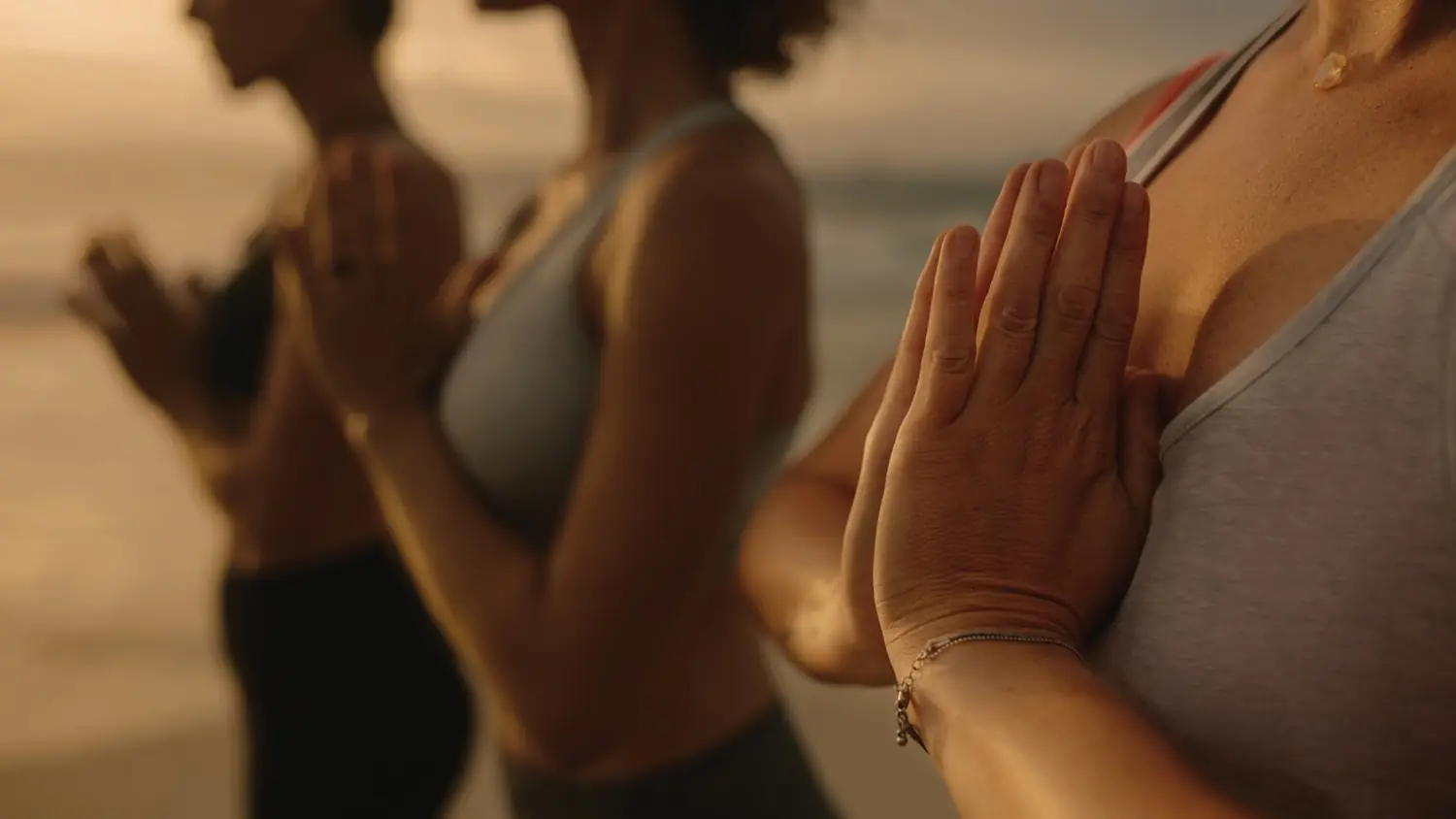 Grupo de personas en saludo de yoga con luz cálida